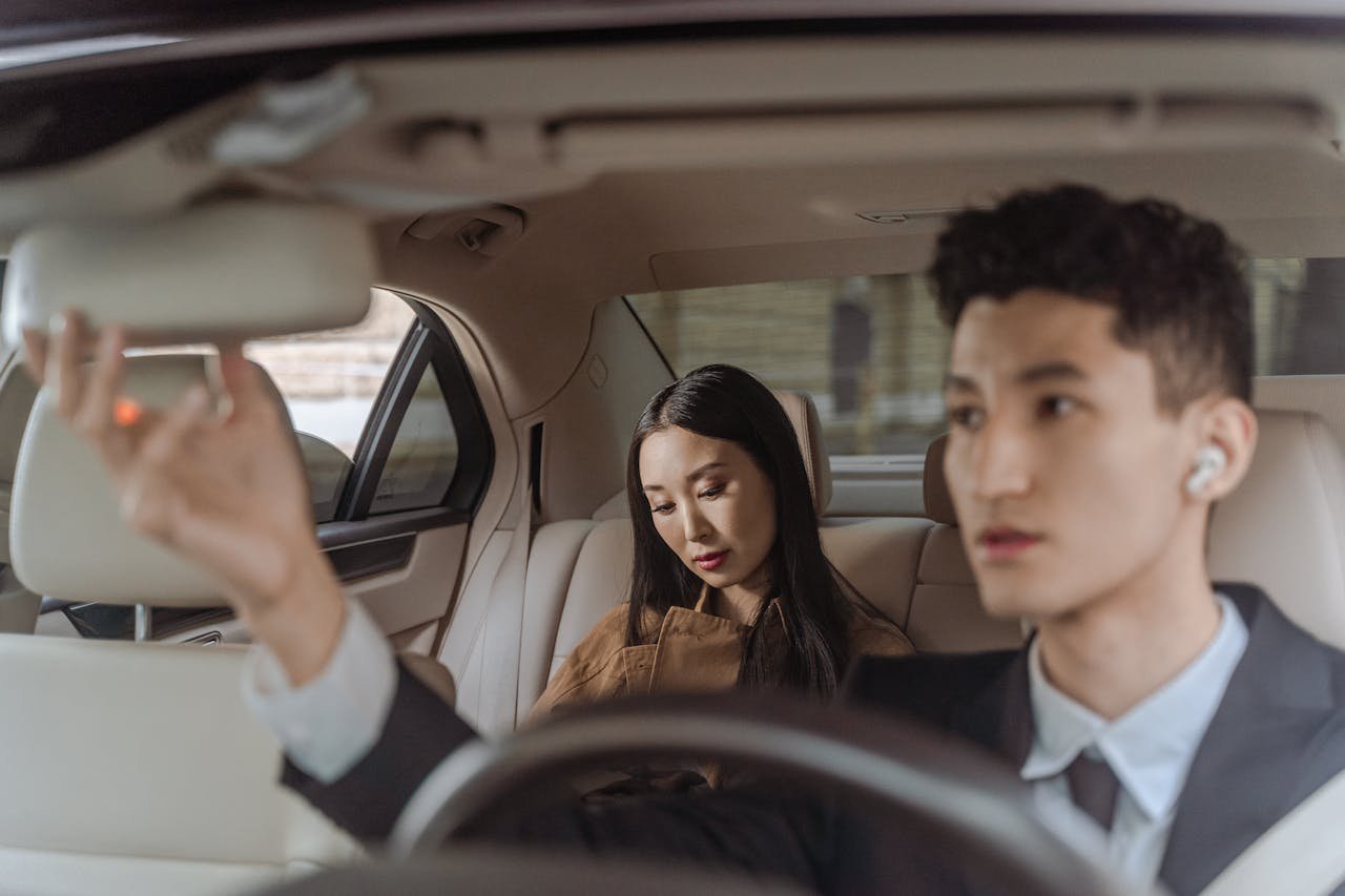 About Elegant Asian business professionals in car showcasing modern interior design and style.